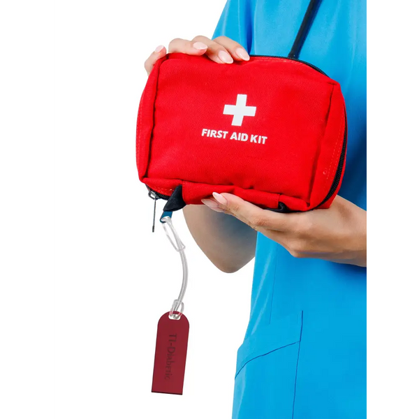 Diabetic luggage tag attached to red first aid kit, highlighting diabetes medical supplies.
