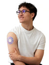 Man wearing a colorful Freestyle Libre 2 adhesive patch on arm, demonstrating secure fit and comfort.