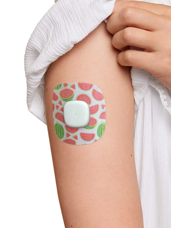 Simplera Sensor Patch with watermelon print on arm, skin-safe adhesive, part of 3-pack design set.