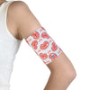 Protective armband with pink heart design securing glucose sensor on teenager's upper arm.