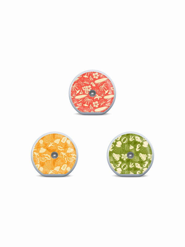 Three Accu-Chek SmartGuide sensor stickers with coral, orange and olive summer doodle patterns on a white background.