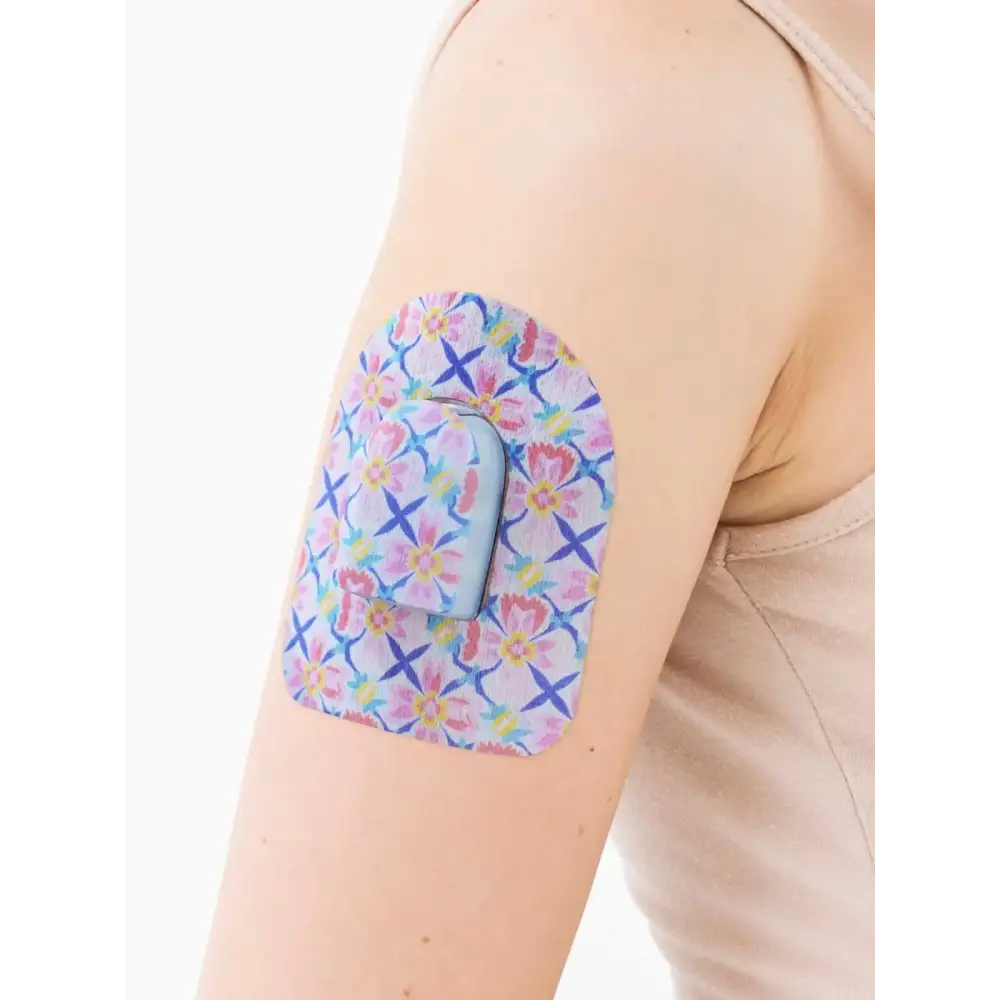 Omnipod Dash patch with spring floral design on person's arm.