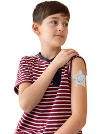 Børneplaster til Dexcom G7, form: stjerne, båret af en dreng