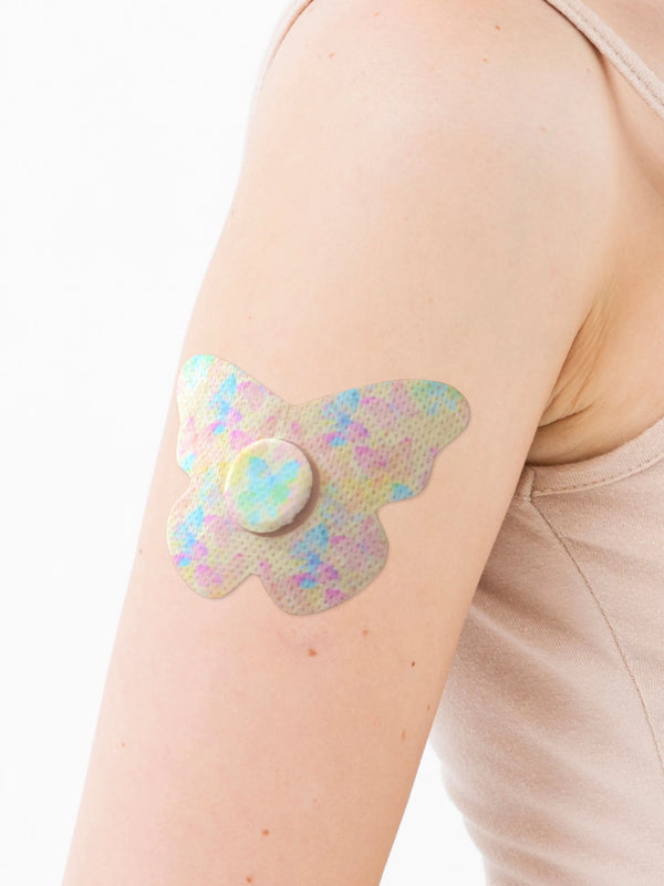 FreeStyle Libre 3 butterfly shape patch close-up on arm, showing breathable adhesive support around the sensor