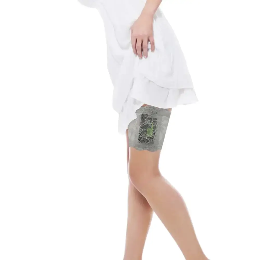 Woman wearing a grey lace garter holding an insulin pump on her thigh under a white dress, lace garter for insulin pump.