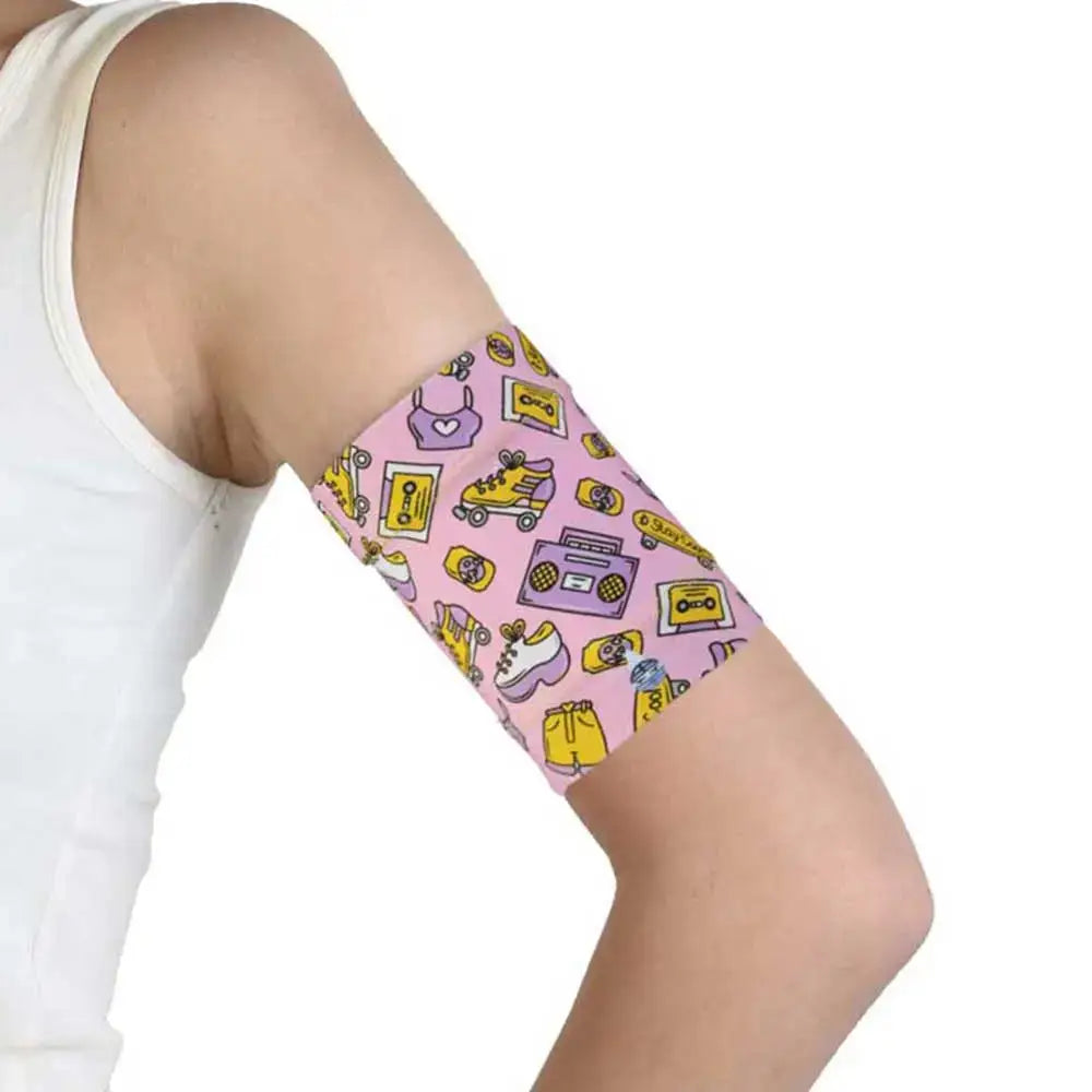 Protective pink armband for glucose sensor with teenager-themed designs worn on upper arm